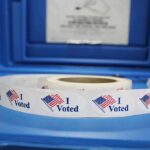 Roll of "I Voted" stickers on table.