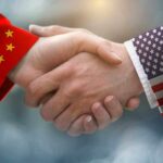 Handshake with China and USA flag sleeves.