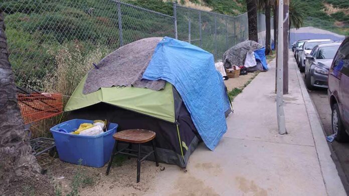 1392494762 featured image Tents and belongings set up along sidewalk.