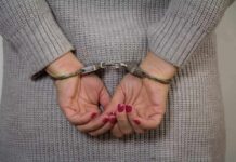 Person with red nails handcuffed from behind