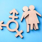Transgender symbol and wooden figures on blue background