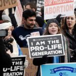 People holding prolife and antiabortion signs at protest