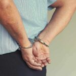 Person in handcuffs wearing striped shirt