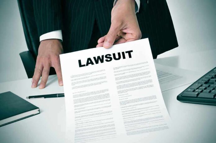 189871757 featured image Person holding a document labeled "Lawsuit."