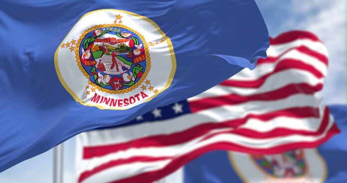 2165286029 featured image Minnesota state flag with American flag in background.