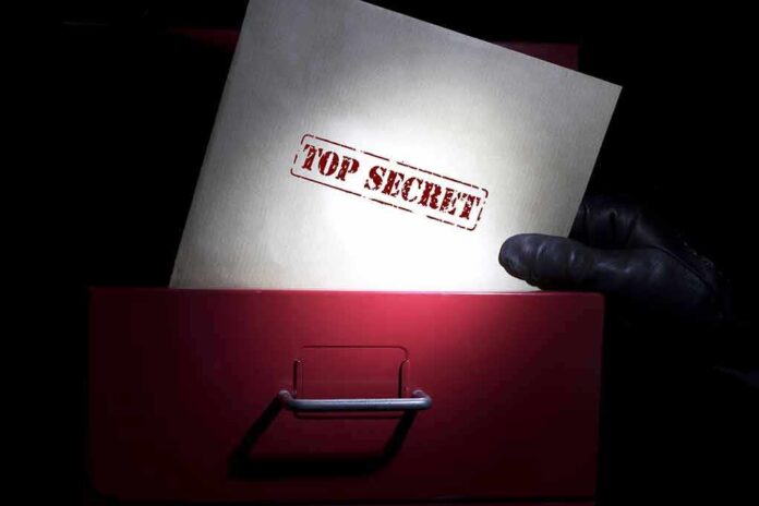 655887151 featured image Gloved hand holding top secret document in file drawer