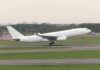 White airplane taking off from a runway.
