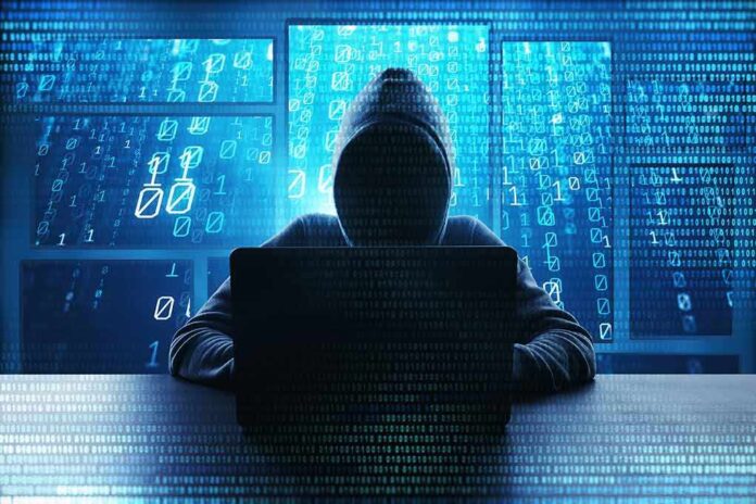 1198362232 featured image Person in hoodie using a laptop with digital code