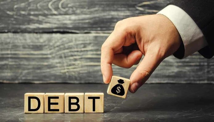 1231457149 featured image Hand replacing debt block with money symbol block