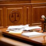 Wooden courtroom desk with papers and a microphone