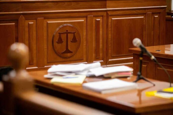 Wooden courtroom desk with papers and a microphone
