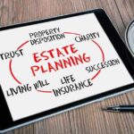 Tablet displaying estate planning related terms nearby coffee cup