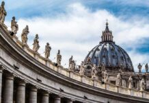 St Peter Basilica dome with statues and clouds