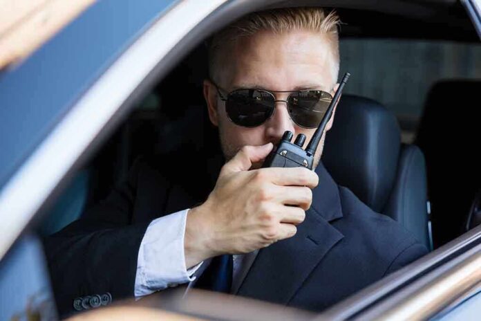 561916870 featured image Man in suit using walkie-talkie in car.