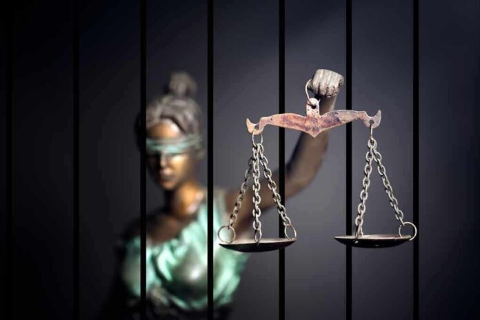 562957564 featured image Blindfolded Lady Justice statue holding scales behind bars