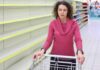 Woman in pink sweater with empty store shelves