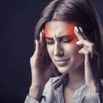 Woman holding head experiencing intense headache or migraine