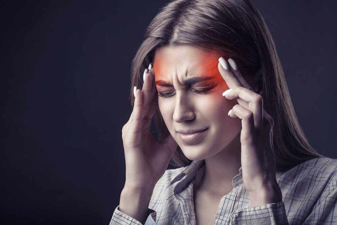 718238359 featured image Woman holding head experiencing intense headache or migraine