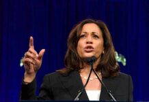 Woman speaking passionately at a podium gesturing upward