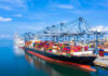 Container ship docked at a busy industrial port