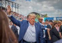 Person in blue suit waving at outdoor event