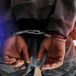 Person in handcuffs with colorful lights in background