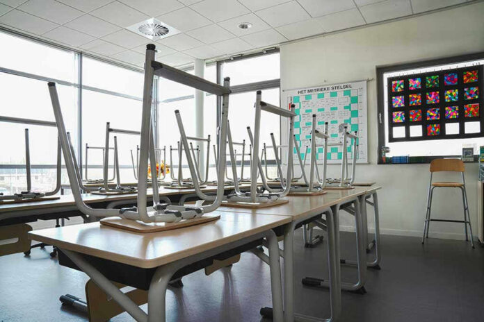 shutterstock1680256285 Empty classroom with chairs on top of desks