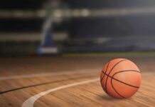 A basketball resting on a wooden court
