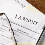 Lawsuit papers with glasses and pen on table