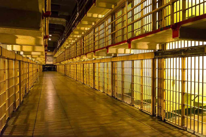 Empty hallway between rows of prison cells