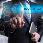 Man in suit pointing at Investigations text