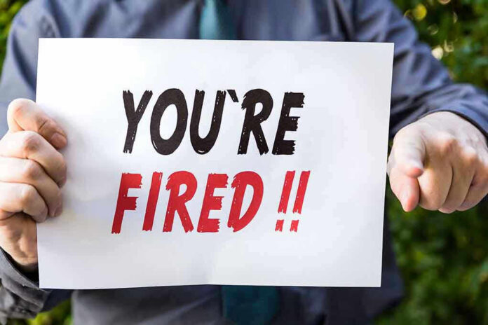 Person holding YOURE FIRED sign