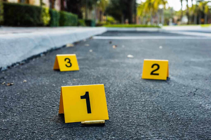 Crime scene markers on asphalt with bullet casing