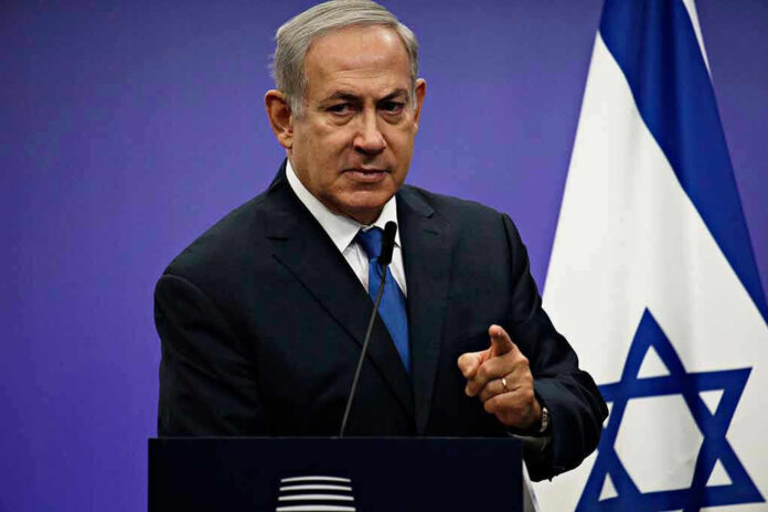 Man in suit giving speech in front of Israeli flag