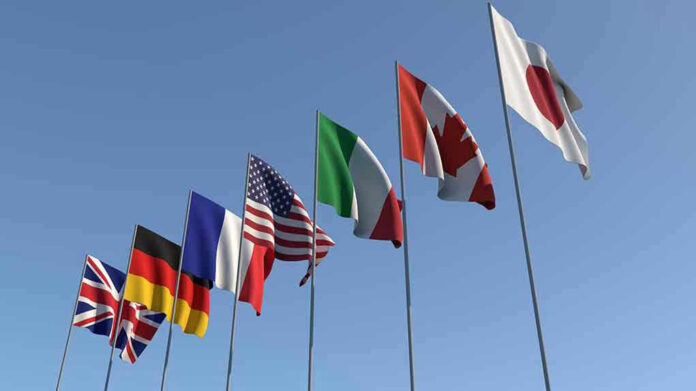 Flags of seven countries against clear blue sky