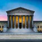 Supreme Court building with illuminated pillars and steps