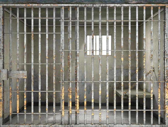 Empty rusty prison cell with a small window