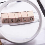 Fraud blocks under magnifying glass on invoices