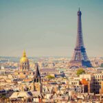 A panoramic view of Paris featuring the Eiffel Tower and a golden dome