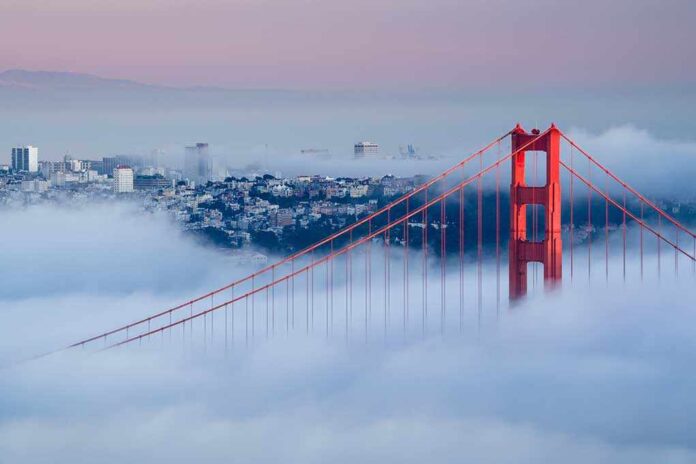 Golden Gate Bridge emerging from fog with San Francisco in the background