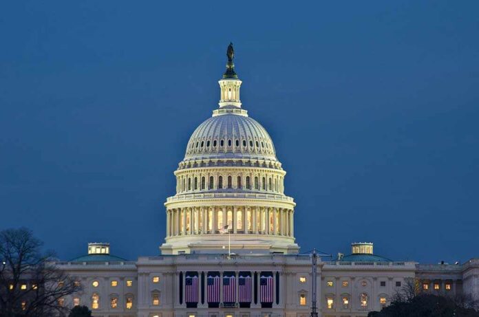 shutterstock_23264335.jpg The US Capitol building illuminated at night with American flags displayed