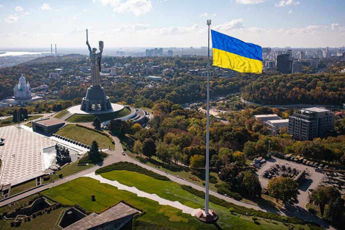 Large Ukraine flag with cityscape in background.