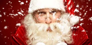 Santa Claus blowing snowflakes with a joyful expression