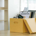 FBI Boss Quits Over ICE Cover-Up Yellow box with resignation notice on an office desk.