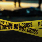 Police tape marking a crime scene at night.