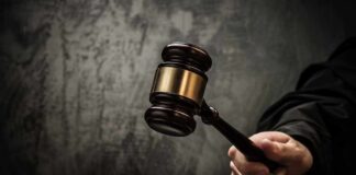 A judges gavel poised to strike a sound block