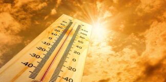 A thermometer displaying temperature against a sunset sky