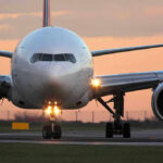 Airplane on runway during sunset.