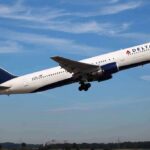 Epstein Files EXPOSE American Express Dark Role Delta Airlines airplane taking off against a blue sky