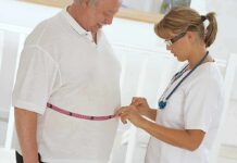 BMI Bombshell: 15-Year Study Stuns A healthcare professional measuring a patients waist with a tape measure